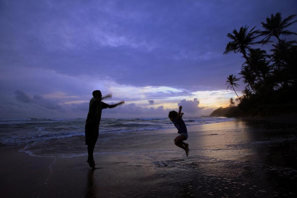 a man and a woman playing on the beach at Amaya Gate in Matara