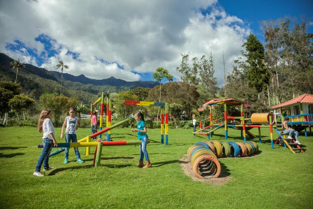 a group of children playing on a playground at Palmas de Cocora in Salento