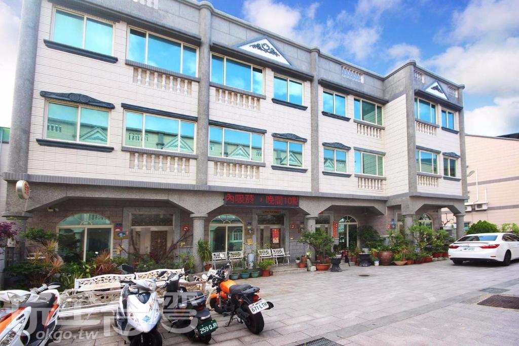 a building with motorcycles parked in front of it at 伯爵四季休閒民宿 in Jinhu