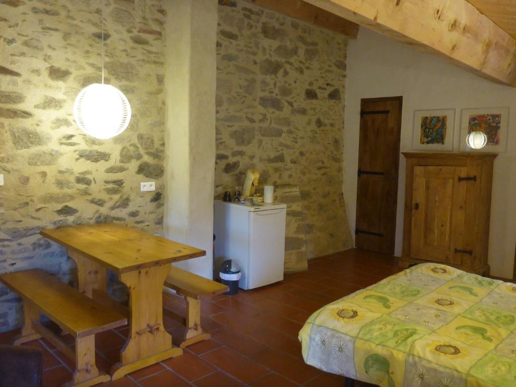 een slaapkamer met een tafel en een bed in een kamer bij Mas Taillet Maison d'Hôtes in Prats-de-Mollo-la-Preste