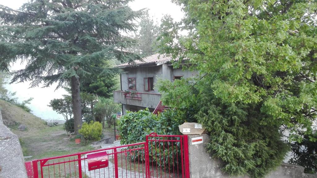 a house with a red fence in front of it at Casa Vacanza Giardino in Guardiabruna
