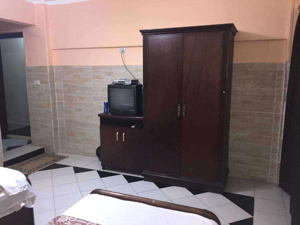 a room with a tv and a cabinet with a televisionictericter at Venus Hostel in Cairo