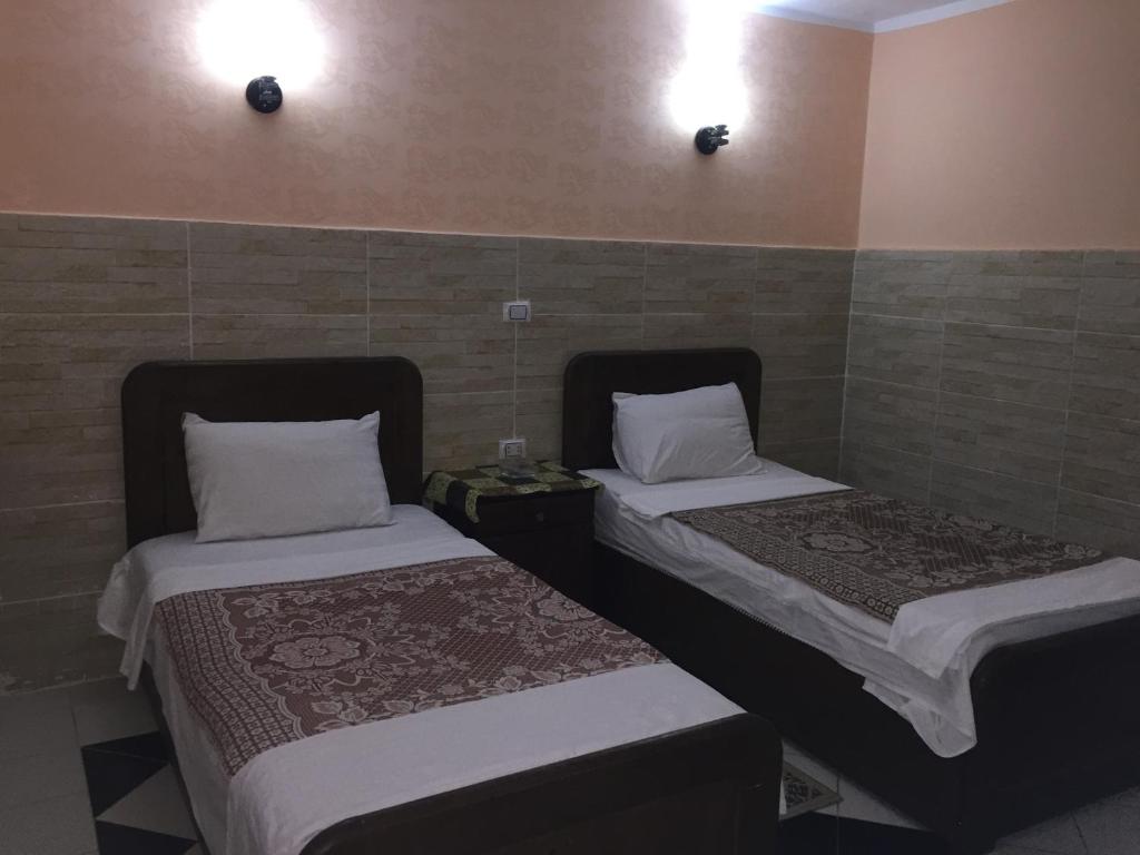two beds sitting next to each other in a room at Venus Hostel in Cairo