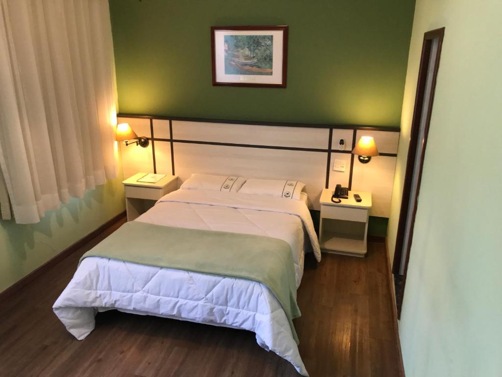 a bedroom with a bed and a green wall at Residencial Pantanal Vila Mariana in Sao Paulo