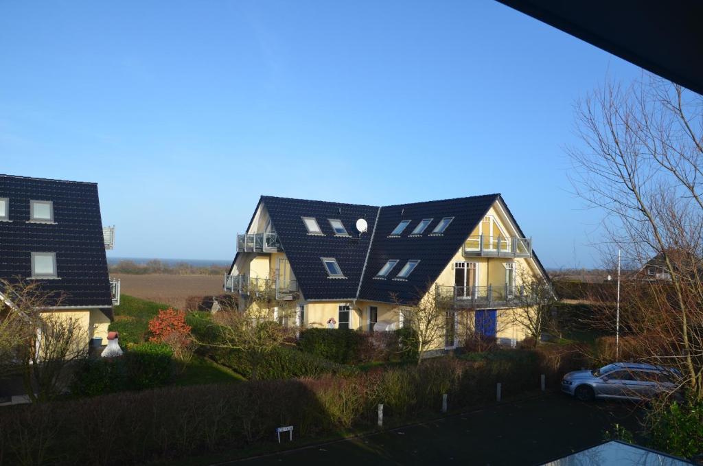 una casa con un techo negro y un coche en Ostseeblick, en Ostseebad Nienhagen