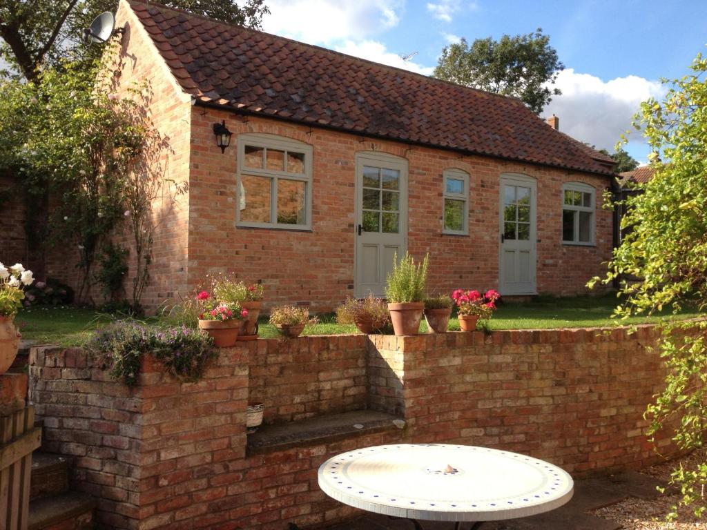 a brick house with a brick wall at Ivy Cottage in Laxton