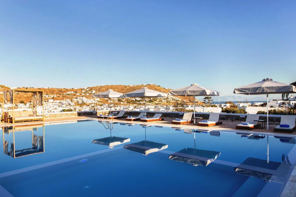einen Pool mit Liegestühlen und Sonnenschirmen in der Unterkunft Osom Resort in Ornos
