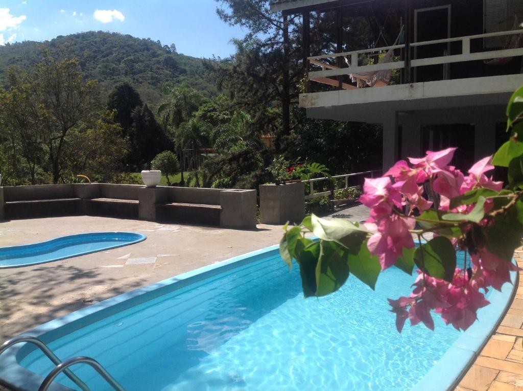 a swimming pool in front of a house at Chacara Mairipora Essence in Mairiporã