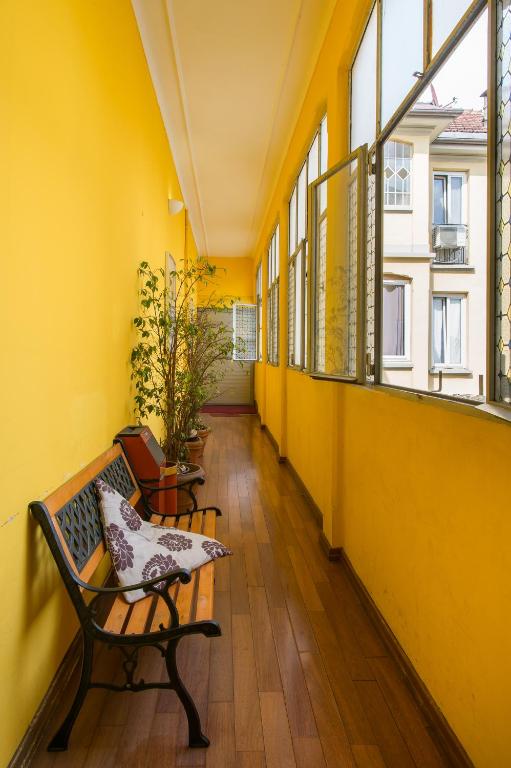 Un pasillo vacío con un banco y ventanas. en Hotel Alpi Resort, en Turín