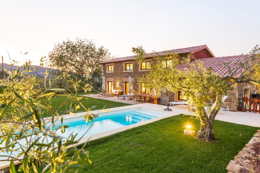 a house with a swimming pool in front of a yard at Quinta do Gato, Douro Valley, Armamar in Armamar