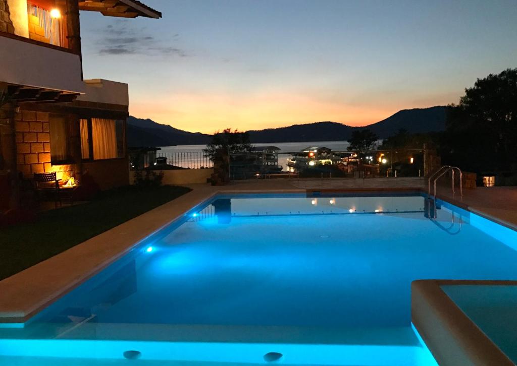 una piscina con tramonto sullo sfondo di Hotel puesta del sol a Valle de Bravo