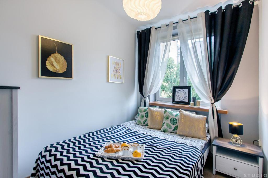 ワルシャワにあるClickTheFlat Avenue Place Apart Roomsのベッドルーム1室(ベッド1台、食料品のトレイ付)