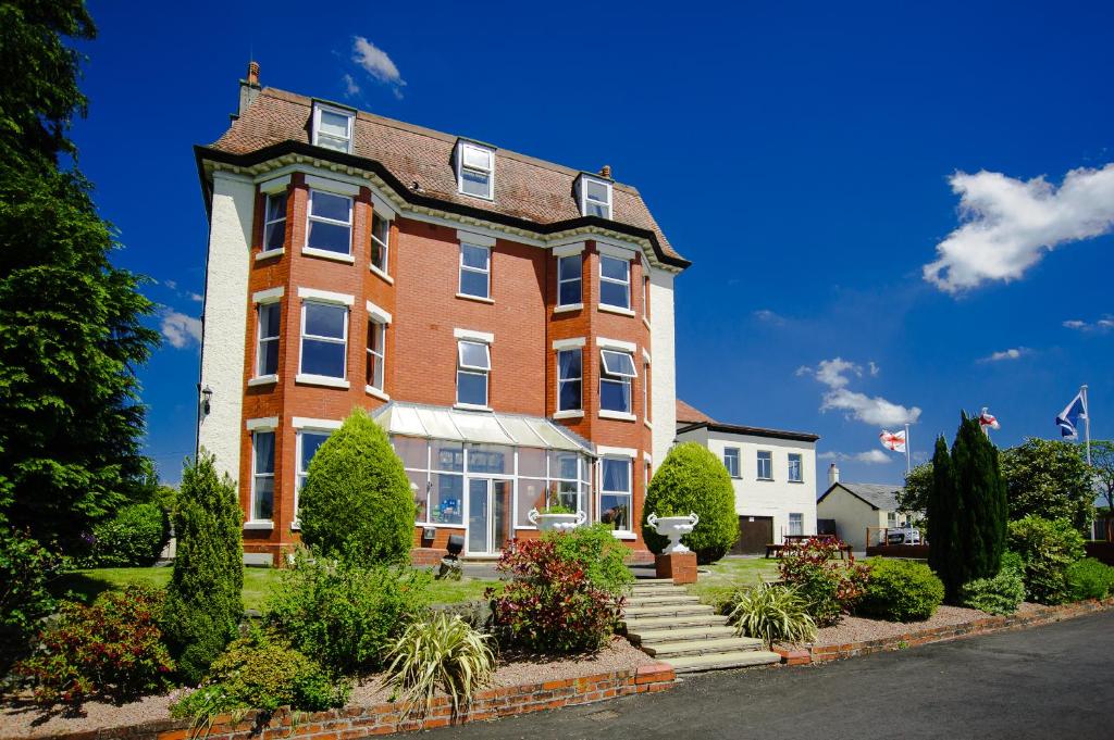 a large red brick building with a roof at Highland Moors in Llandrindod Wells