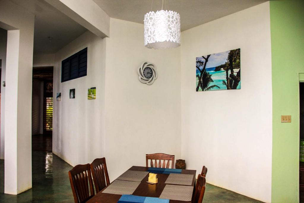 a dining room with a table and a chandelier at Sunshine Lodge: Your home away from home in Montego Bay