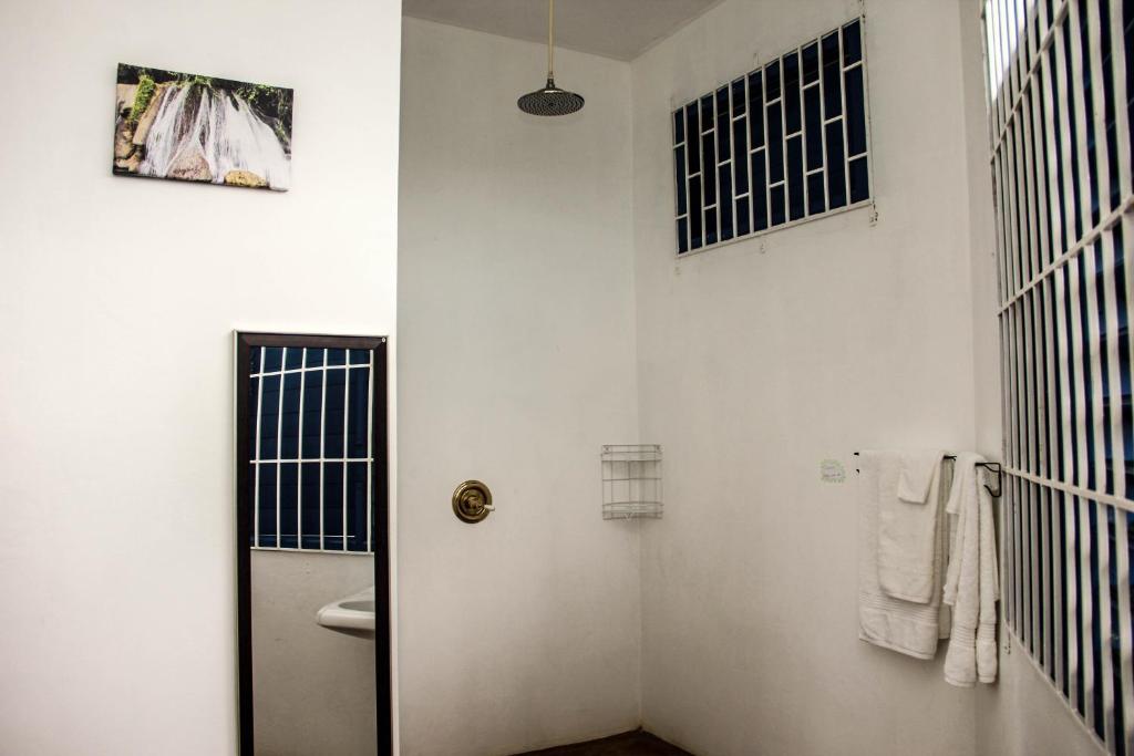 a white bathroom with a toilet and a sink at Sunshine Lodge: Your home away from home in Montego Bay