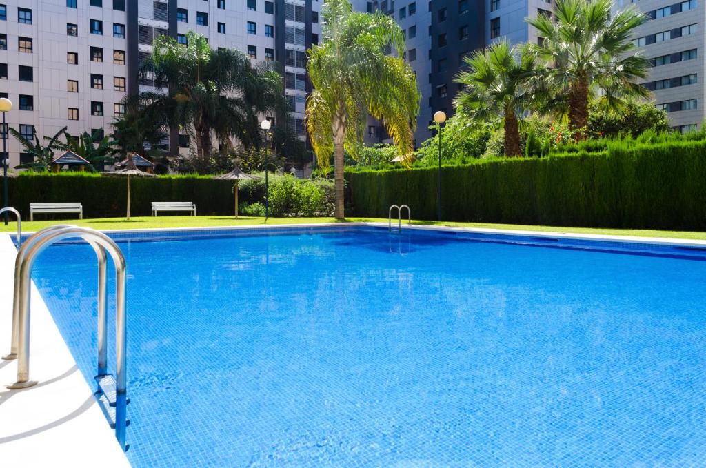 a large blue swimming pool with buildings in the background at ApartUP Francia Views in Valencia