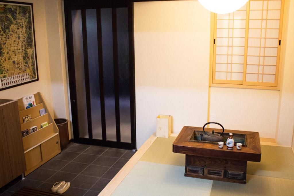 a living room with a table and a lamp at Kamoya Ryokan in Kyoto