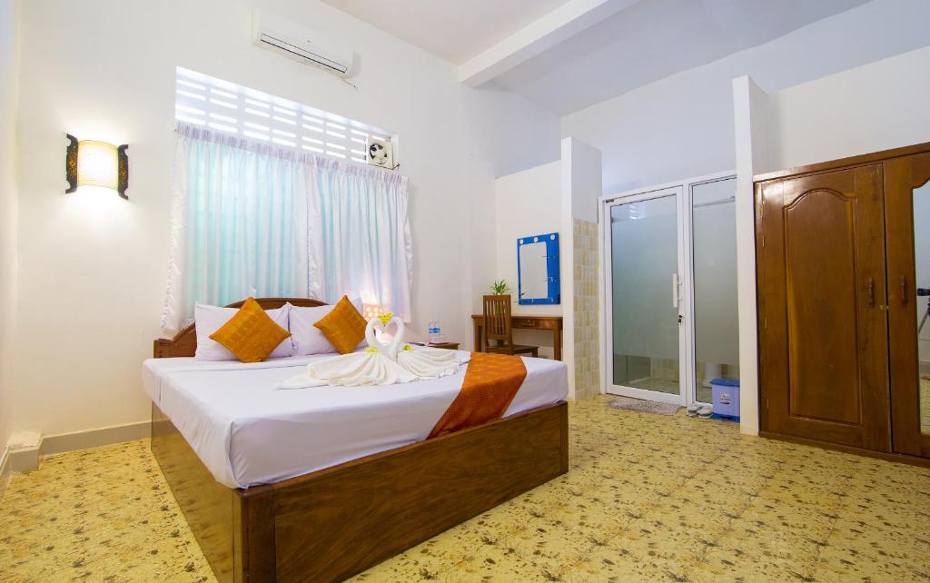 a bedroom with a large bed and a window at Blossoming Romduol Boutique in Siem Reap
