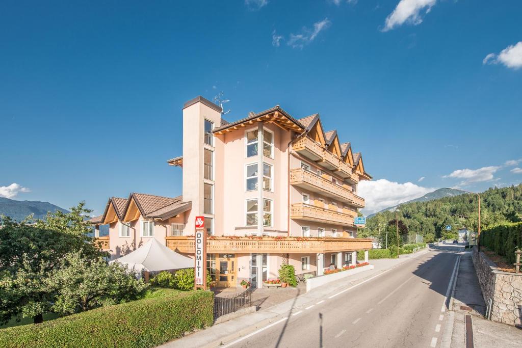 ein großes Gebäude am Straßenrand in der Unterkunft Hotel Dolomiti in Vattaro