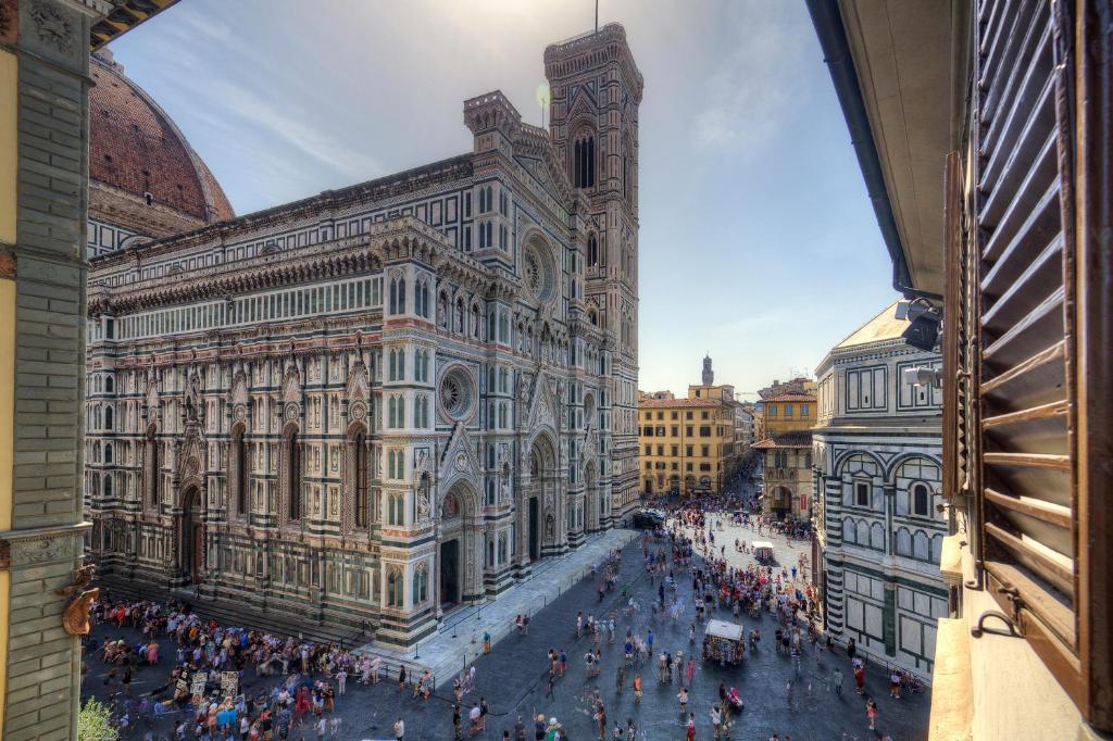una folla di persone che si alzano fuori da un edificio di Flower Cathedral Firenze a Firenze