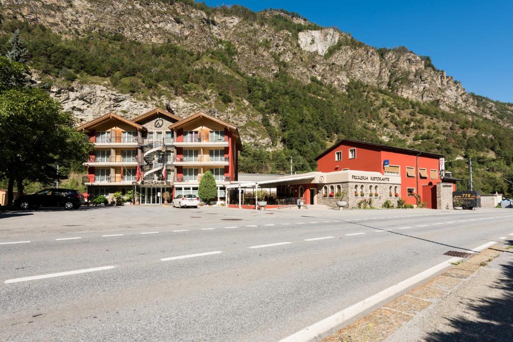 um edifício ao lado de uma estrada com uma montanha em Hotel-Restaurant Ackersand em Ackersand