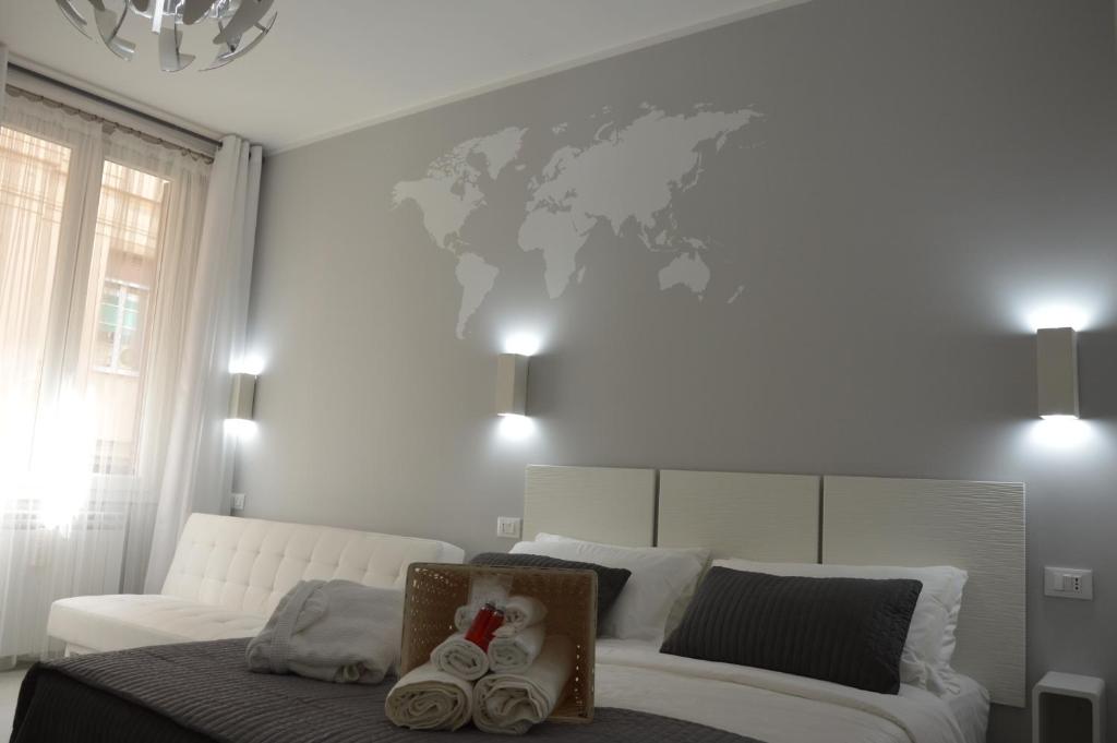 una camera da letto con un letto bianco e una mappa del mondo sul muro di Ca dei Nobili a Genova