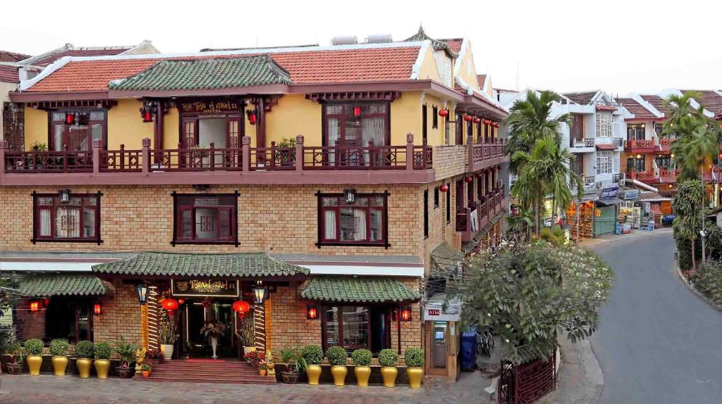 a large brick building with a balcony on a street at Thanh Binh 2 Hotel in Hoi An