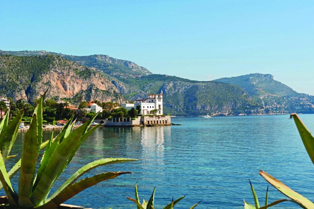 a view of a large body of water with mountains at Hôtel Vacances Bleues Delcloy in Saint-Jean-Cap-Ferrat