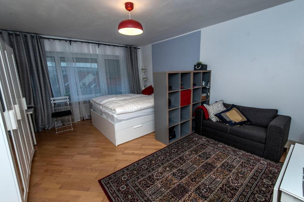una piccola camera con letto e divano di Lovely studio in Augsburg a Augusta (Augsburg)