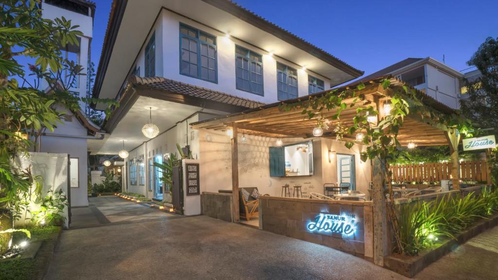 an exterior view of a house at night with lights at Sanur House in Sanur