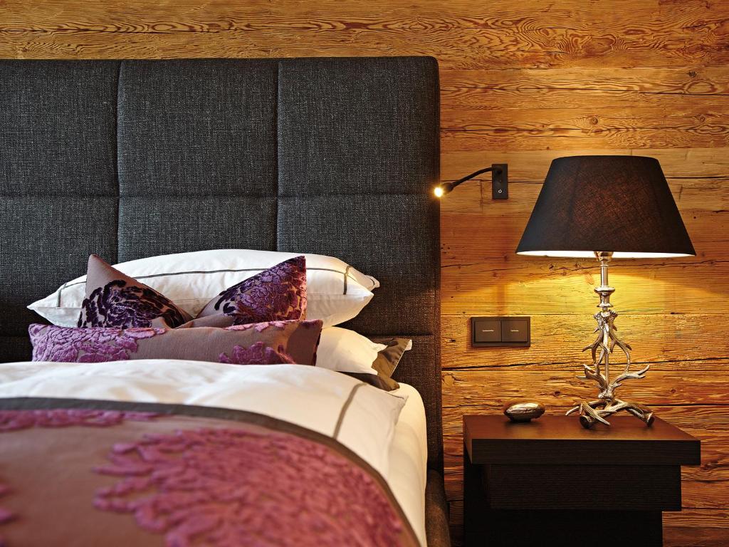 a bedroom with a bed and a lamp on a table at Chalet-F in Ofterschwang