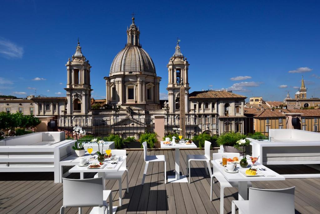a view of a rooftop restaurant with tables and chairs at Lifestyle Suites Rome in Rome