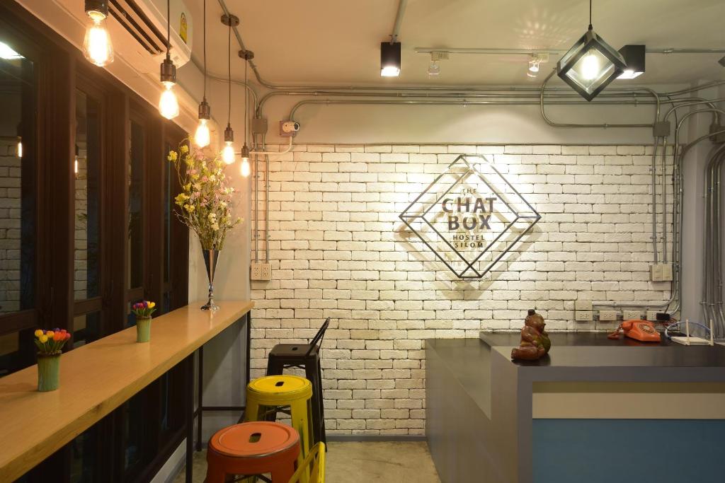 a kitchen with a counter and a brick wall at The Chatbox Silom Hostel in Bangkok