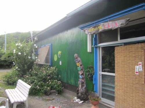 屋久島にあるとまり木のベンチ横に像のある緑の建物