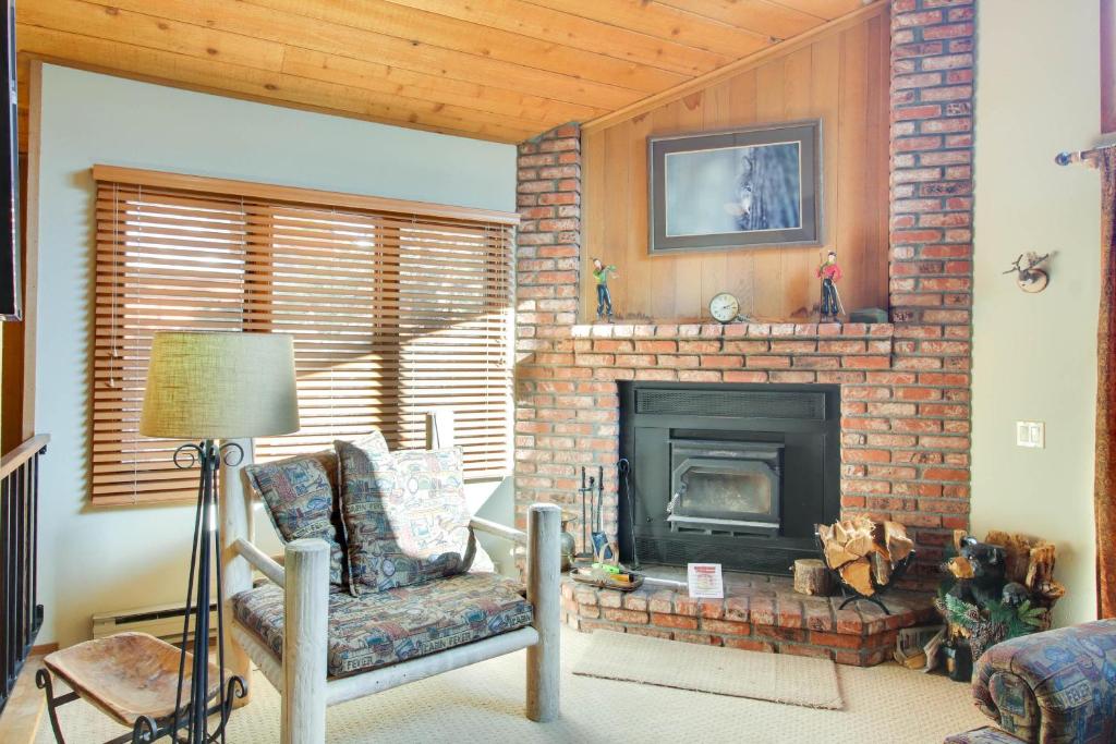 a living room with a brick fireplace and a chair at Woodlands 34 in Mammoth Lakes