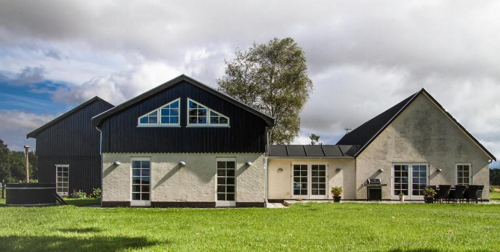 ein Haus mit einem schwarzen Dach und einem grünen Hof in der Unterkunft Øvej 18 Holiday House in Ringsted