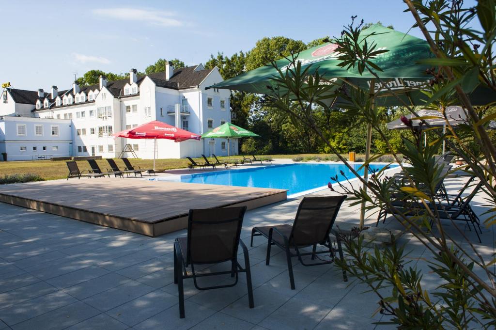 a patio with a table and chairs and a pool at Hotel Galant Lednice in Lednice