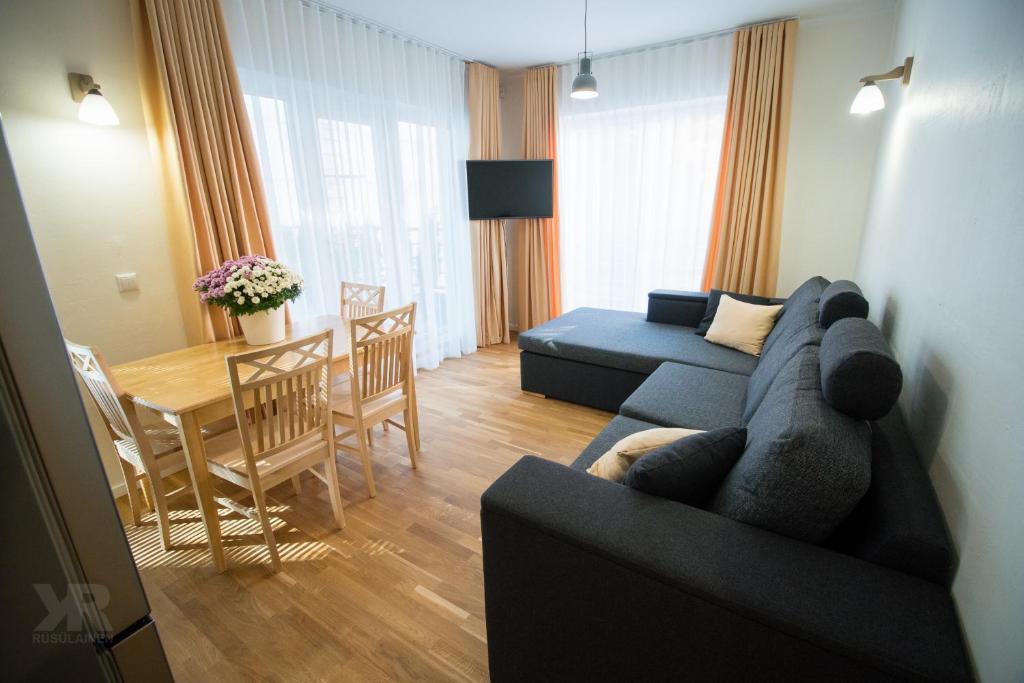 Maria Apartments في تارتو: غرفة معيشة مع أريكة زرقاء وطاولة