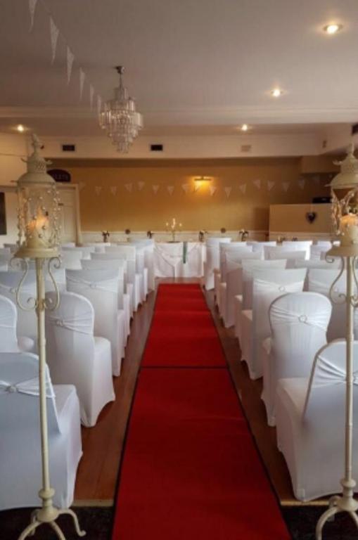 a room with white chairs and a red carpet at Hatton's of Garadice in Garadice