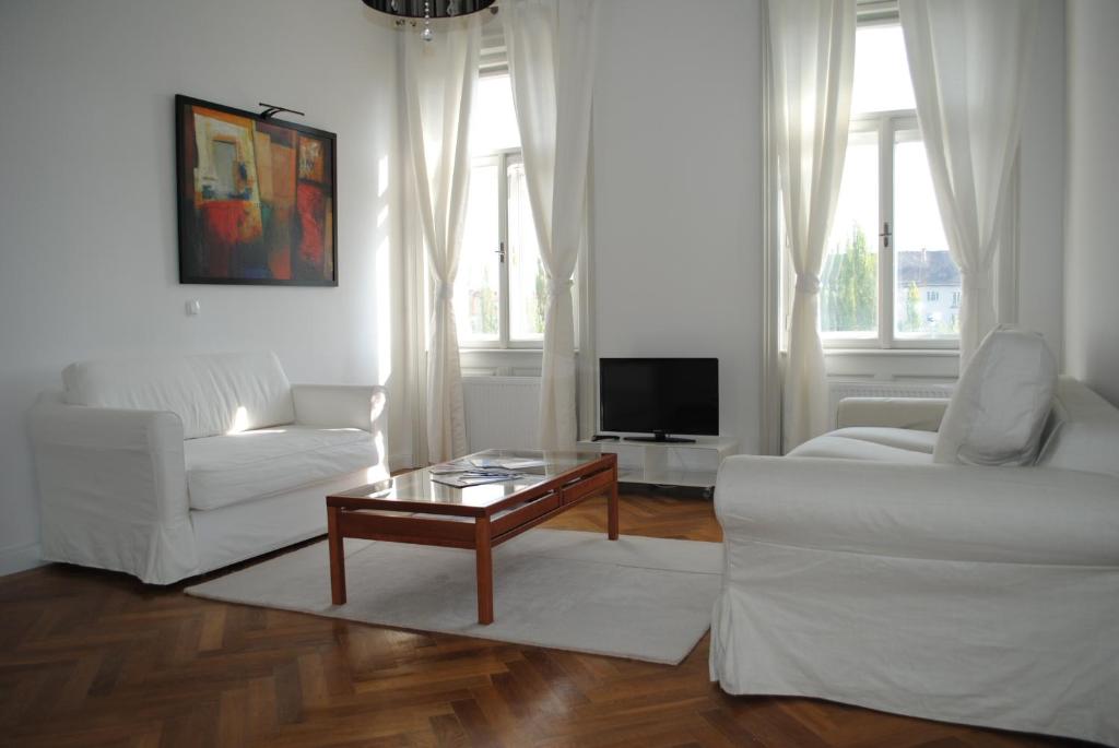 a living room filled with furniture and a window at Kunsthaus Apartments in Vienna