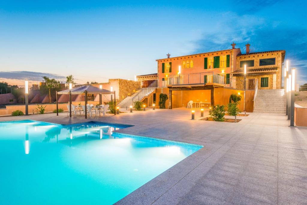 eine Villa mit einem Pool vor einem Gebäude in der Unterkunft Sa Montanyeta in Manacor