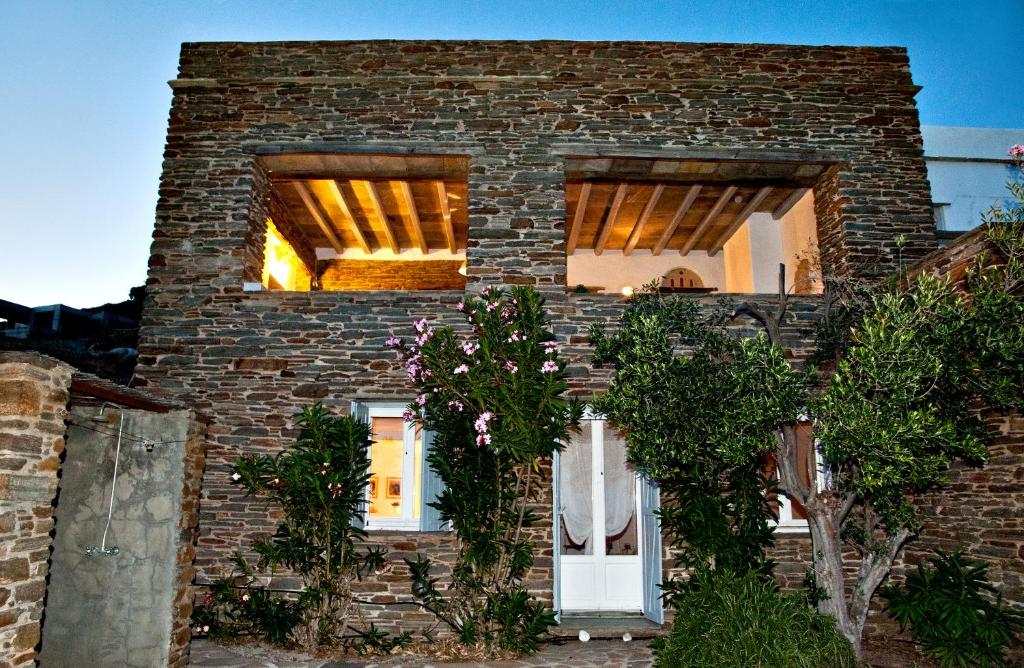 アギオス・ソスティスにあるAenaos Villa Tinosの白いドアと窓のあるレンガ造りの家