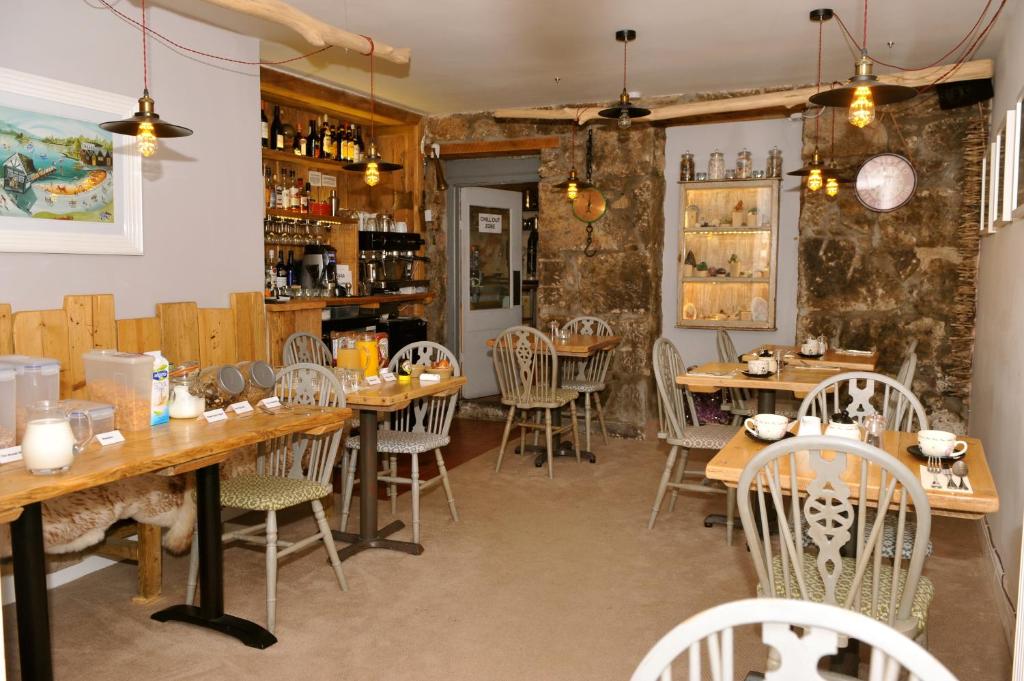 a dining room with wooden tables and chairs at Sea View Guest House in Benllech