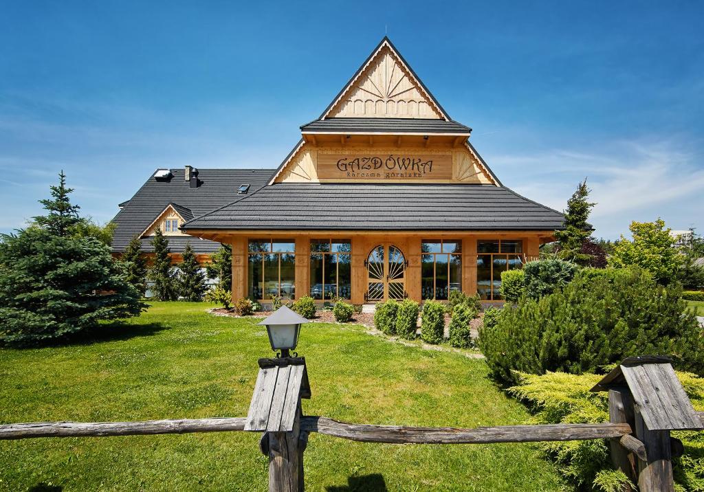 a building with a fence in front of it at Hotel Gazdówka Spa in Osielsko