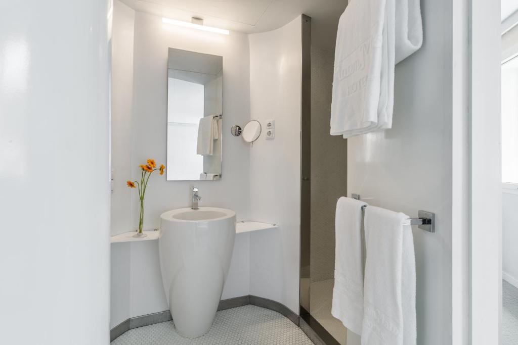 a white bathroom with a sink and a mirror at Room Mate Oscar, Madrid in Madrid