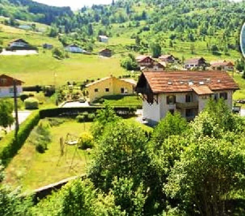 un pequeño pueblo con una casa en una colina en Résidence du Chajoux, en La Bresse