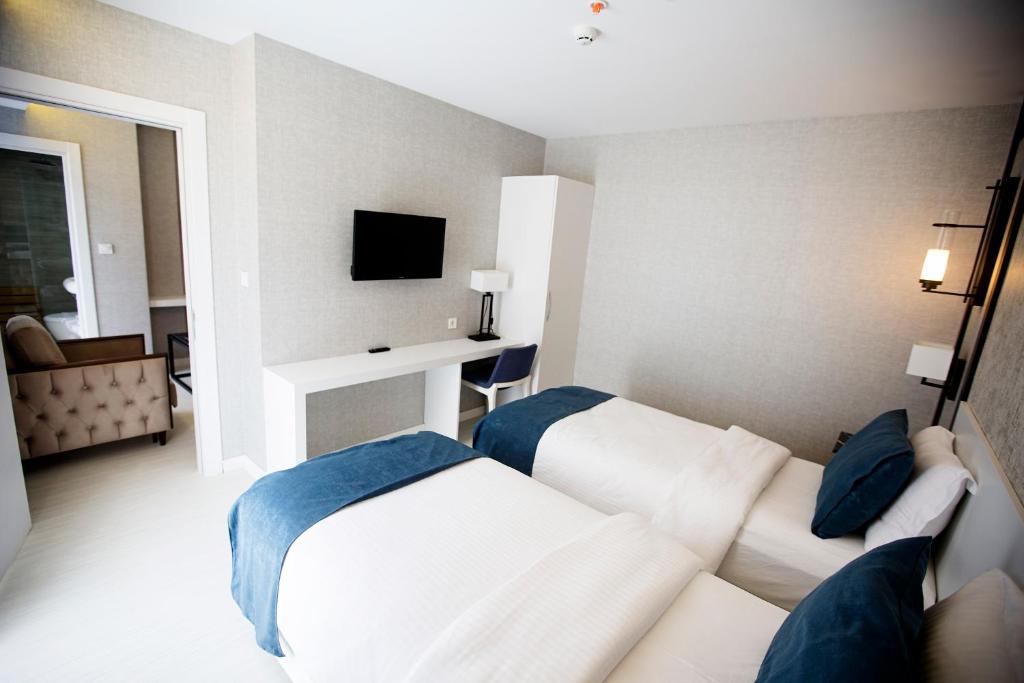a hotel room with two beds and a television at Gardenya Suite Hotel in Trabzon