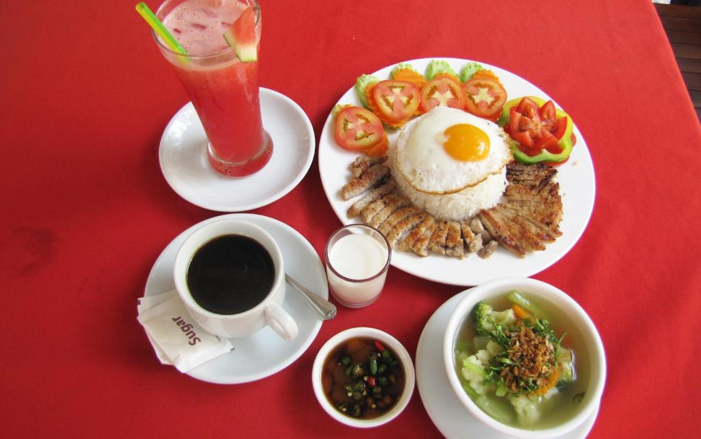 a red table with a plate of food and a cup of coffee at Blossoming Romduol Boutique in Siem Reap