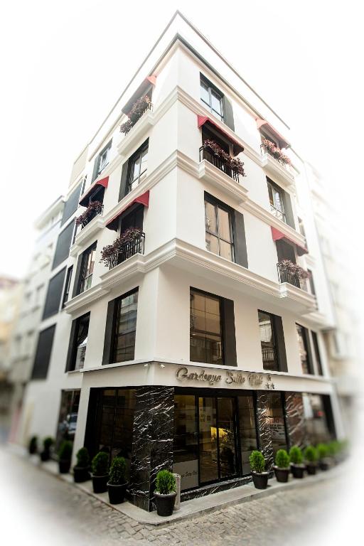 a white building with potted plants in front of it at Gardenya Suite Hotel in Trabzon
