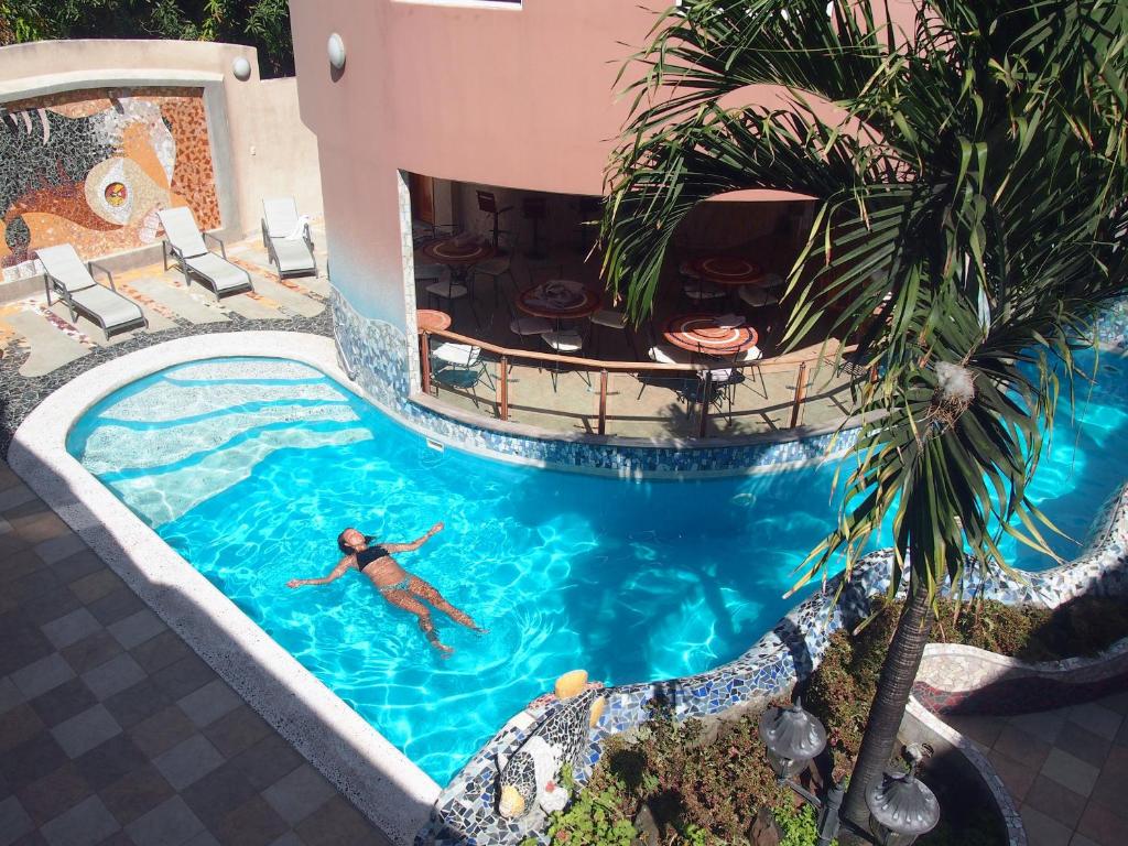 un hombre nadando en una piscina en una piscina en Eco Hotel Katarma en Puerto Baquerizo Moreno